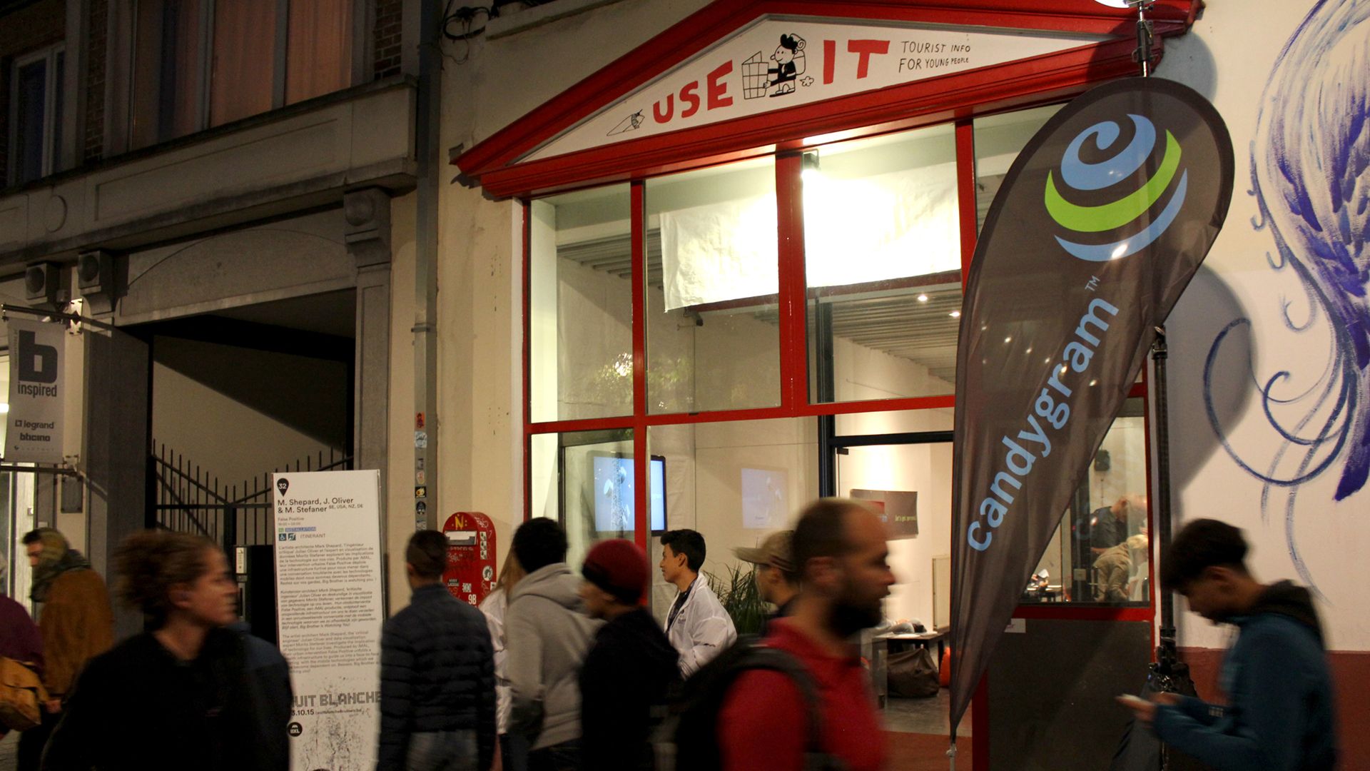Nighttime crowd passing the Candygram popup shop entrance at Nuit Blanche in Brussels