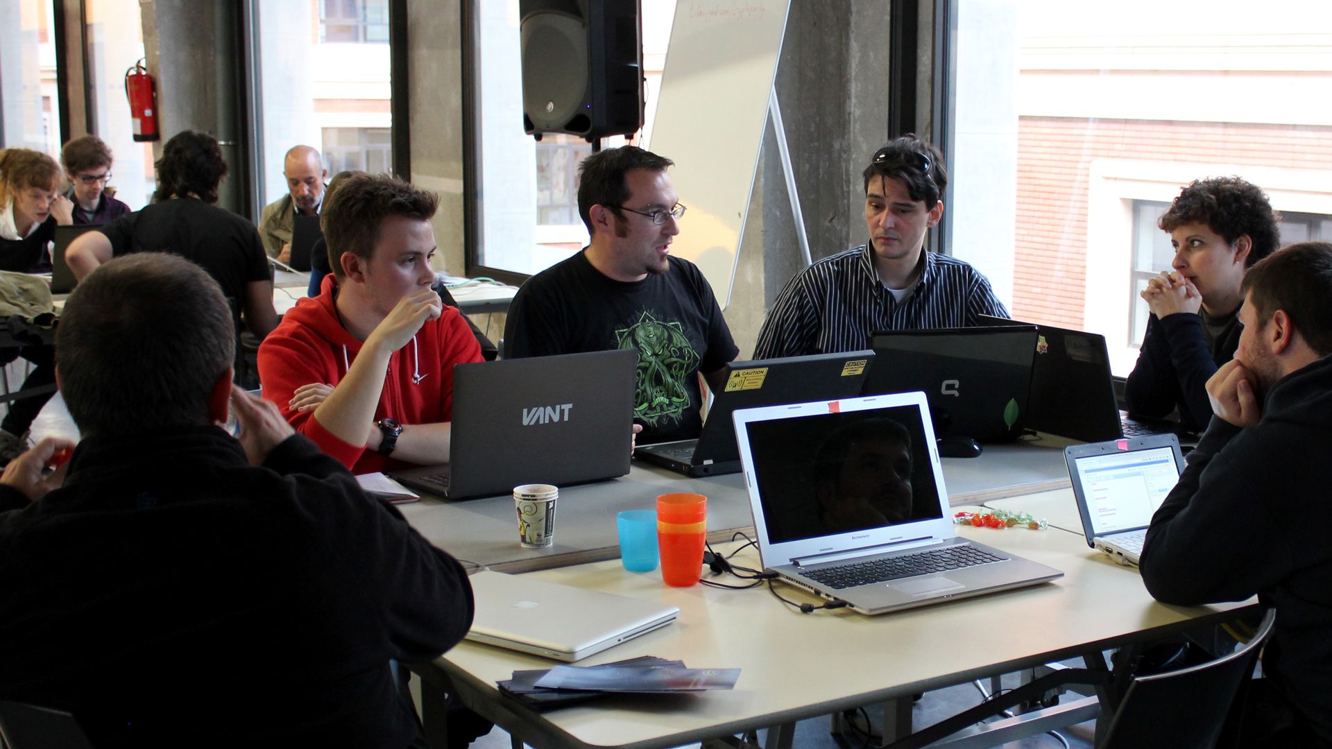 Cryptoparty workshop with participants gathered around laptops at a table